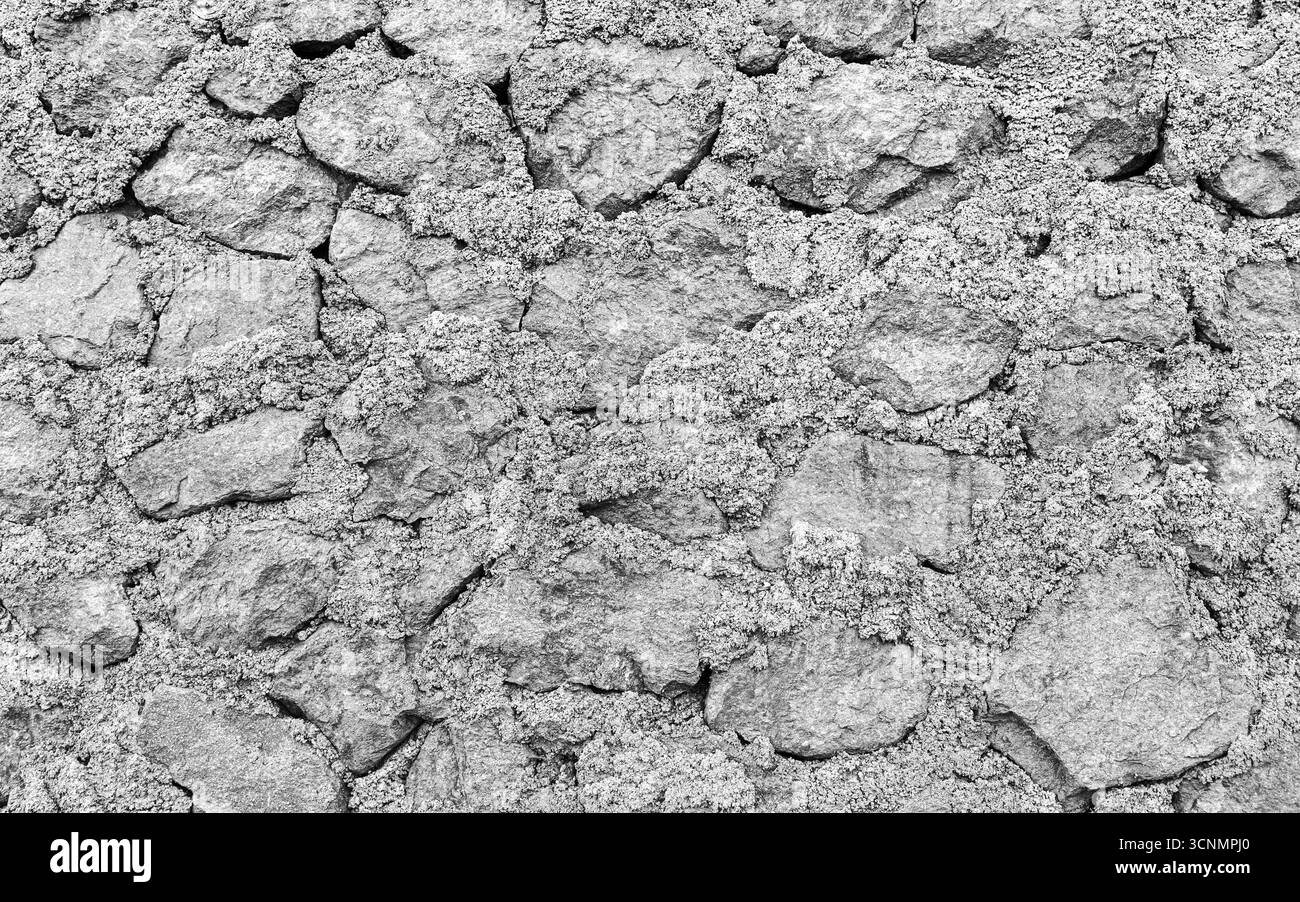 Una vecchia parete grigia in pietra grezza, texture per foto di sfondo, vista frontale Foto Stock