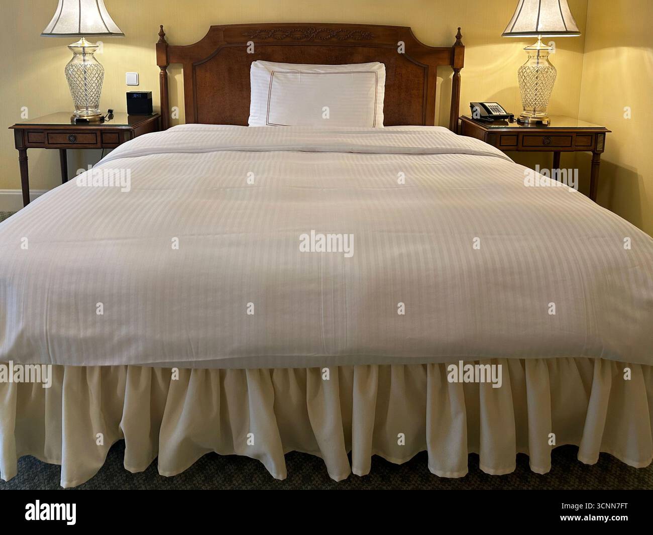 Letto grande e comodo e arredamento moderno in un'elegante camera d'hotel Foto Stock