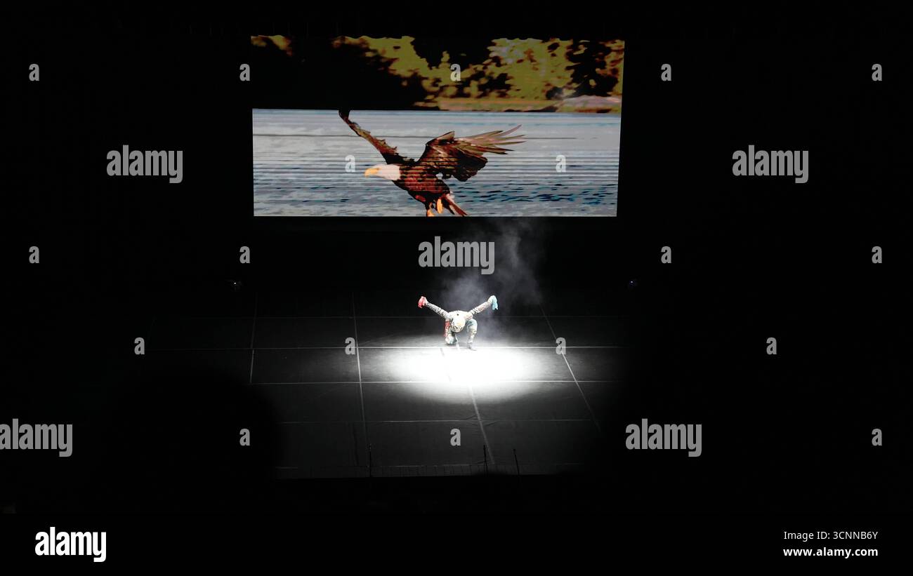 Fuoco dell'Anatolia o Anadolu AteÅüi si esibiscono con scene di danza tradizionali e contemporanee che celebrano il patrimonio anatolico Un ballerino maschile si esibisce da solo sul palco con un'aquila proiettata dietro di lui, spargendo le braccia per rispecchiare le ali degli uccelli. Questa scena simbolica fa parte del repertorio Fire of Anatolias. Gaziantep Türkiye Copyright: XMohammadxBashirxAldaherx Foto Stock