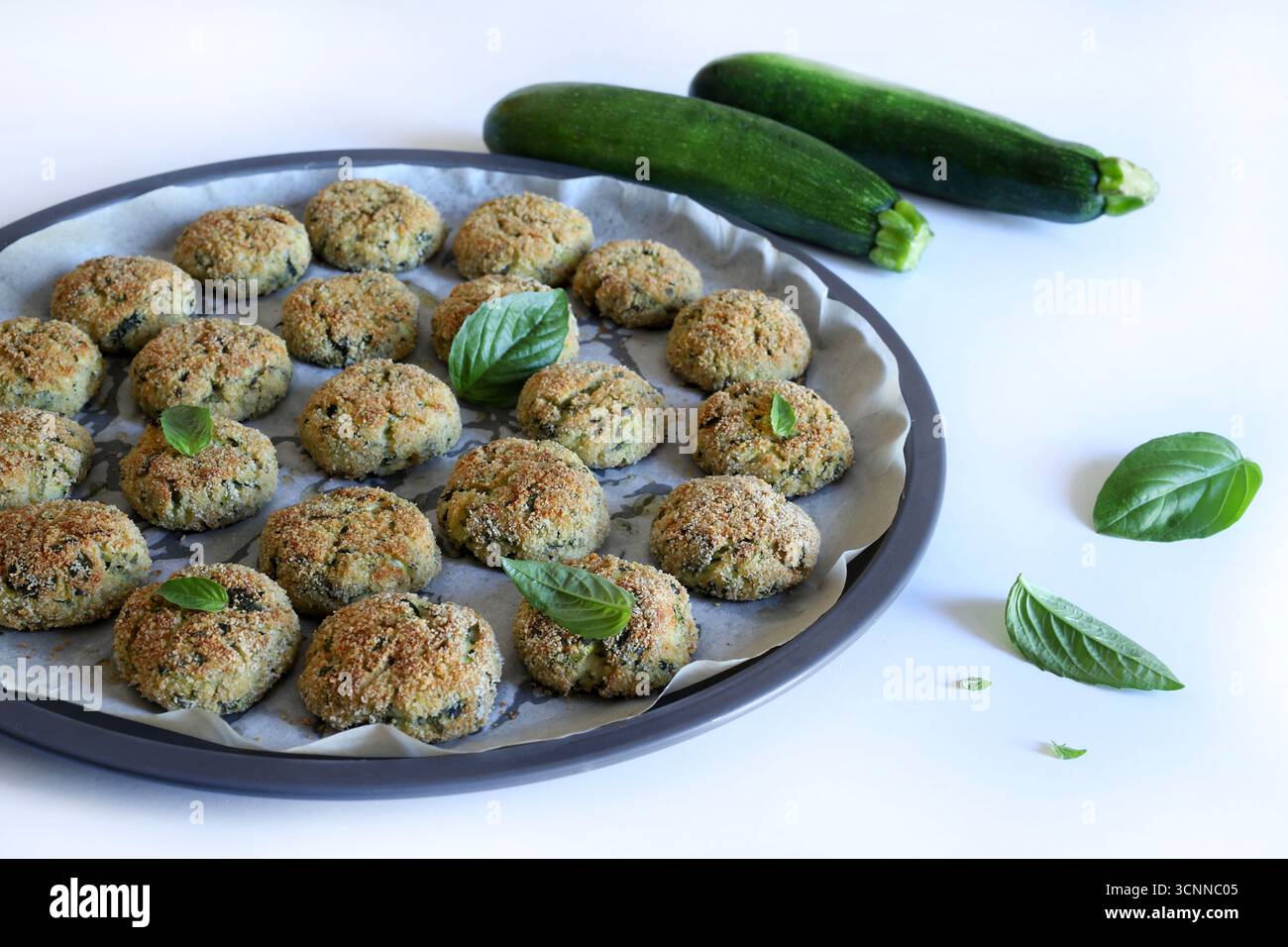 Palle di zucchine fatte in casa su un tavolo di legno bianco. Cucina sana e vegana. Copia spazio. Direttamente sopra. Foto Stock