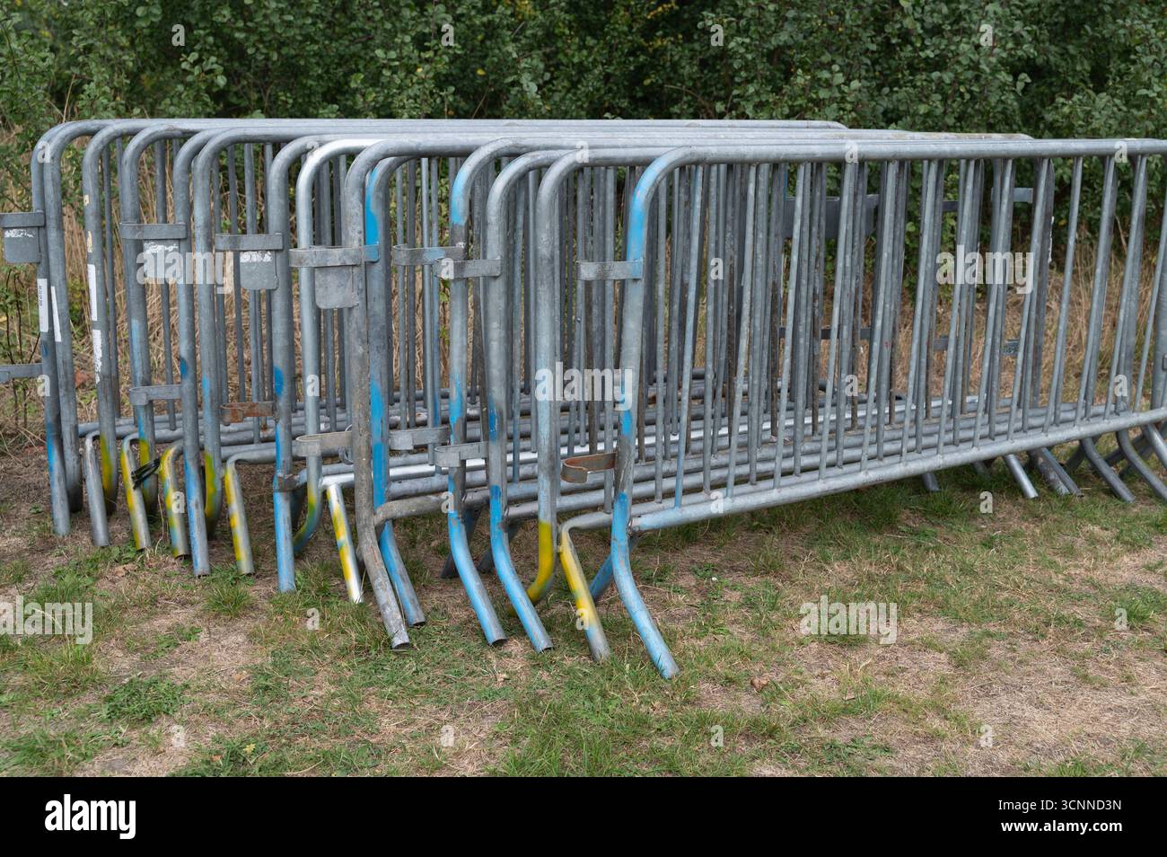 Una vasta collezione di barriere metalliche è stata accuratamente impilata l'una sull'altra in modo organizzato e pronto all'uso Foto Stock