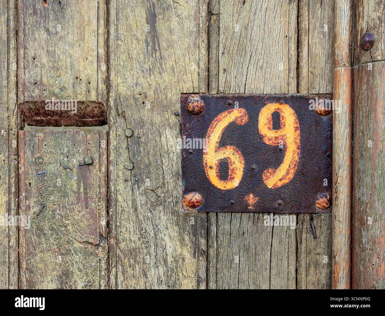 Vecchia casa arrugginita dipinta a mano numero sessantanove / soixante-neuf in Rue Voltaire, Chinon, Indre-et-Loire (37), Francia. Foto Stock