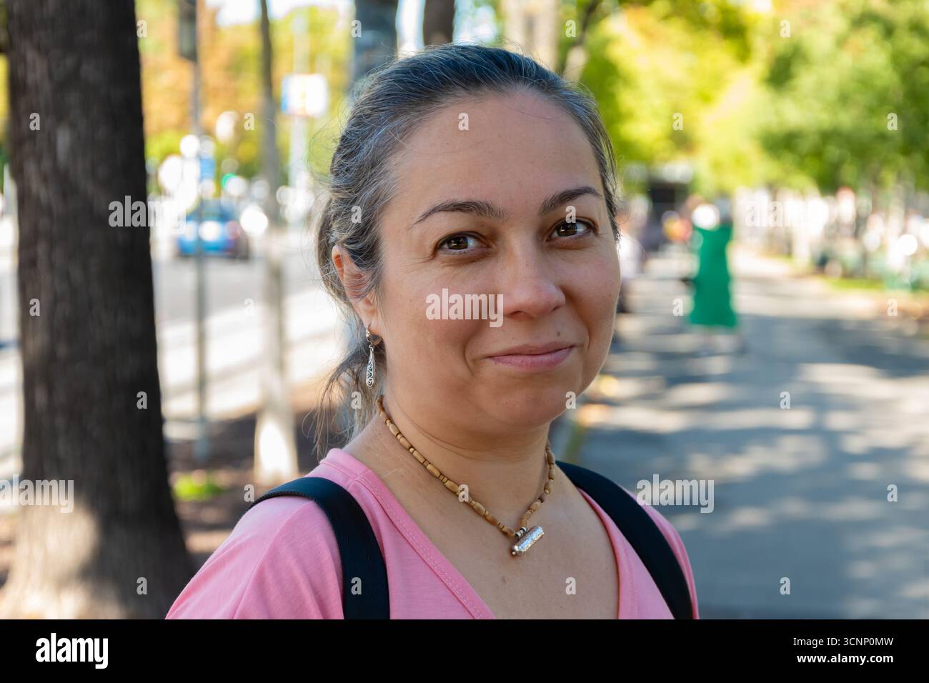 Una donna di 40-45 anni in abiti casual con uno zaino sulle spalle Foto Stock