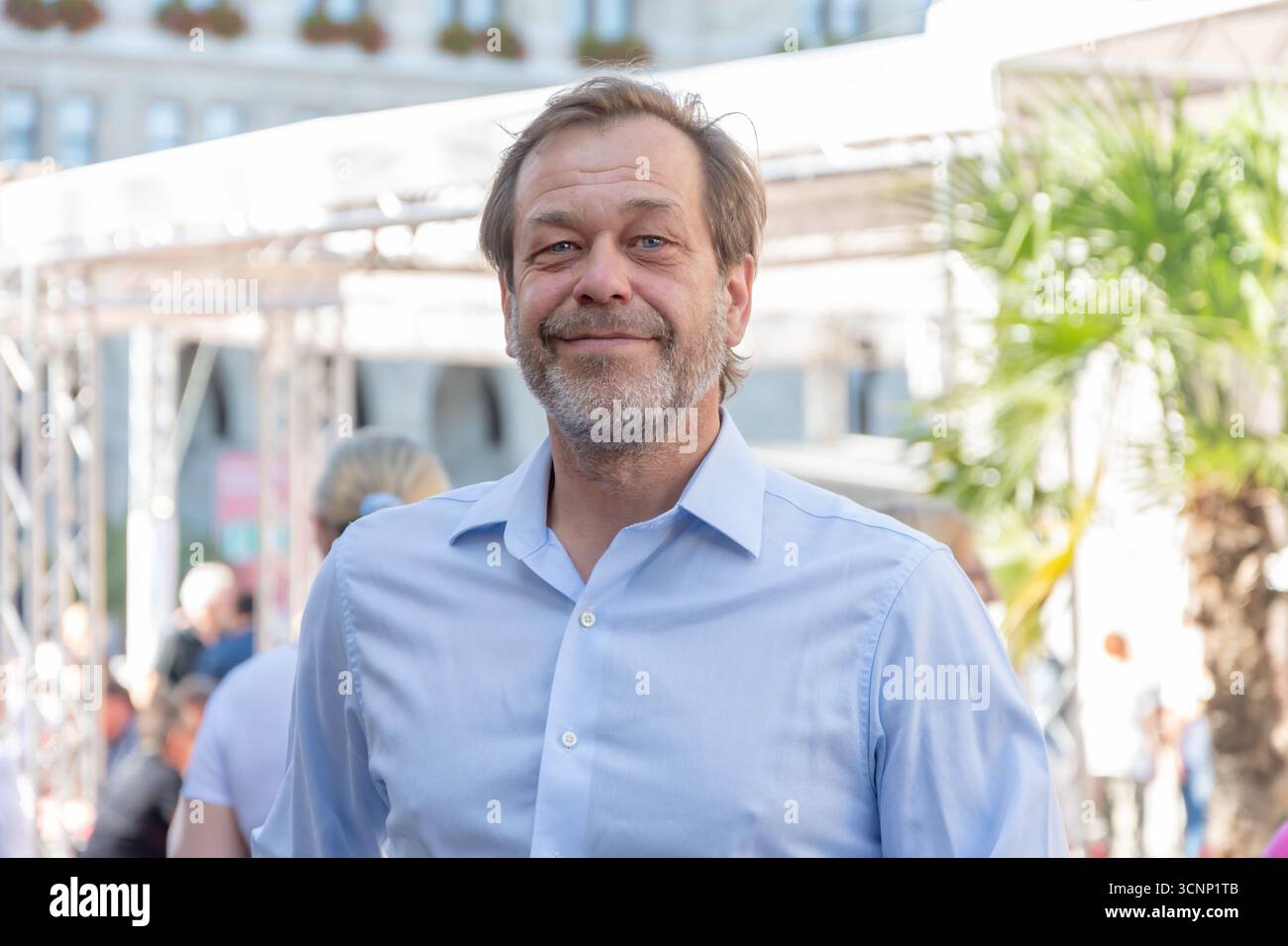 Ritratto emozionale di un uomo di 50-55enne con barba su sfondo urbano sfocato, primo piano Foto Stock