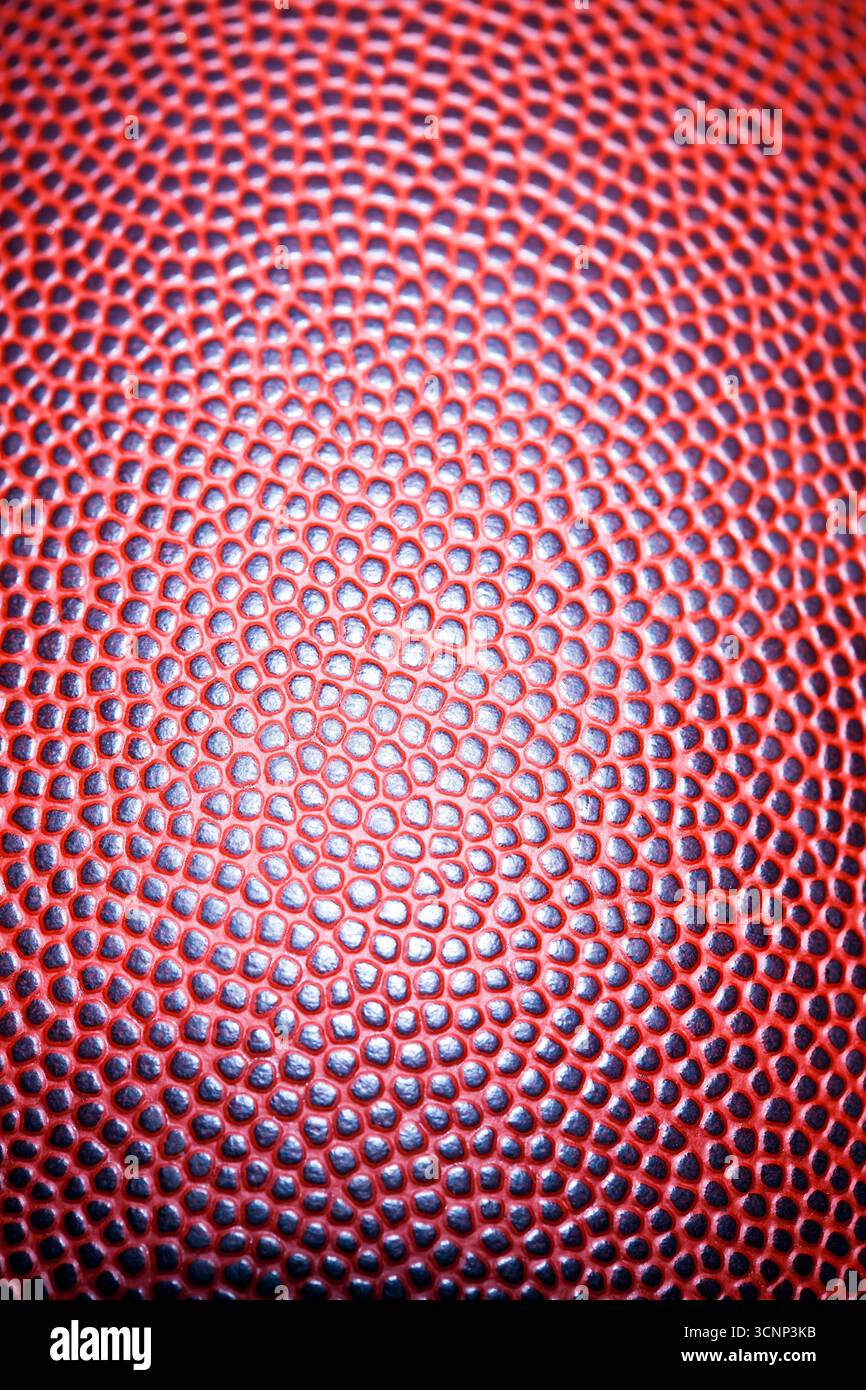 Un primo piano di un football americano rivela una texture dettagliata della pelle e cuciture precise, fotografate in uno studio su sfondo nero, Highli Foto Stock