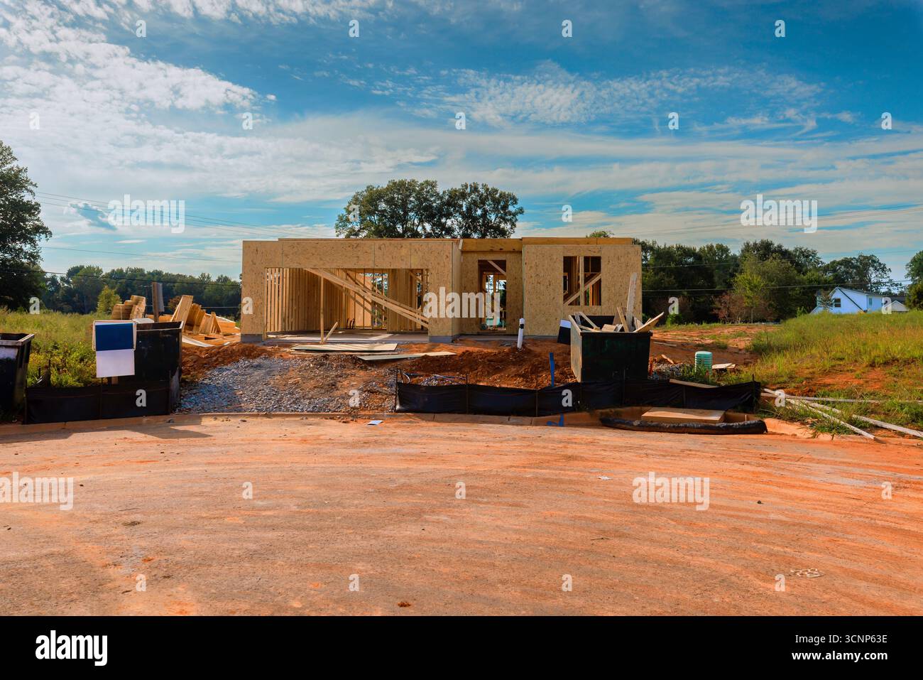 Costruisci una nuova casa prende forma con telai in legno durante il giorno dei lavori nel quartiere in via di sviluppo. Foto Stock
