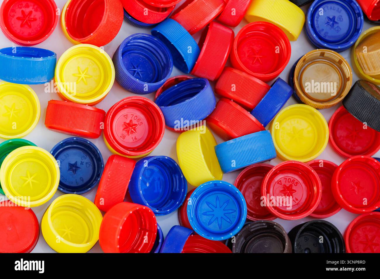 Pile di tappi in plastica multicolore utilizzati per il riciclaggio. Oggetti in plastica riciclabili come concetto ambientale. Foto Stock