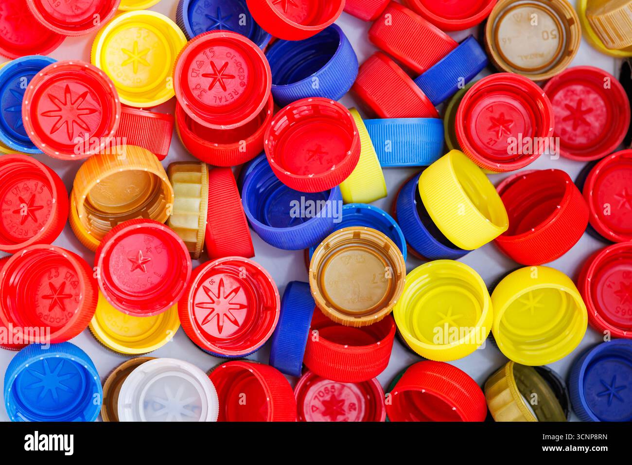 Primo piano di tappi per bottiglie multicolore per il riciclo. Fondo riciclabile in tappi di plastica. Foto Stock
