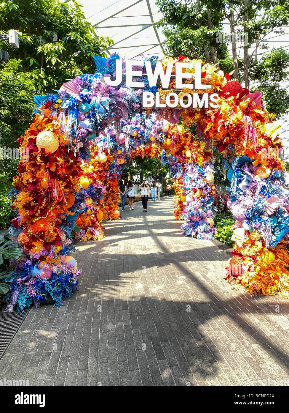 Ingresso principale per i visitatori presso i Jewel Blooms, decorato con plastica colorata e fiori di carta nello stesso aerostazione dell'indù più alto del mondo - Immagine stock catturata con smartphone