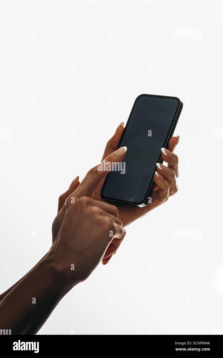 Primo piano di una mano che interagisce con uno smartphone moderno, evidenziando i gesti touch e la tecnologia. Foto Stock