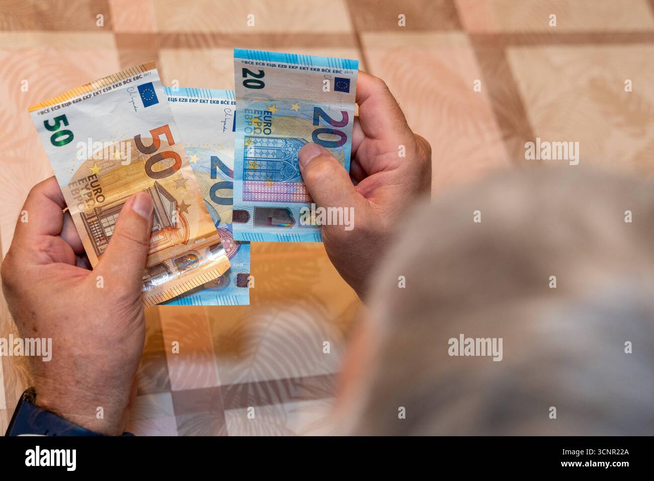 Germania - 21 settembre 2025: Un uomo anziano ha in mano banconote da 50 e 20 euro. L'immagine simboleggia la sicurezza finanziaria nella vecchiaia e rappresenta i temi delle pensioni, delle pensioni e dei pagamenti pensionistici. *** Ein Alter Mann hält 50 und 20 Euro-Scheine in den Händen. DAS Bild symbolisiert die finanzielle Sicherheit im alter und steht für das Thema Rente, Altersvorsorge und den Bezug von Rentenzahlungen. Foto Stock