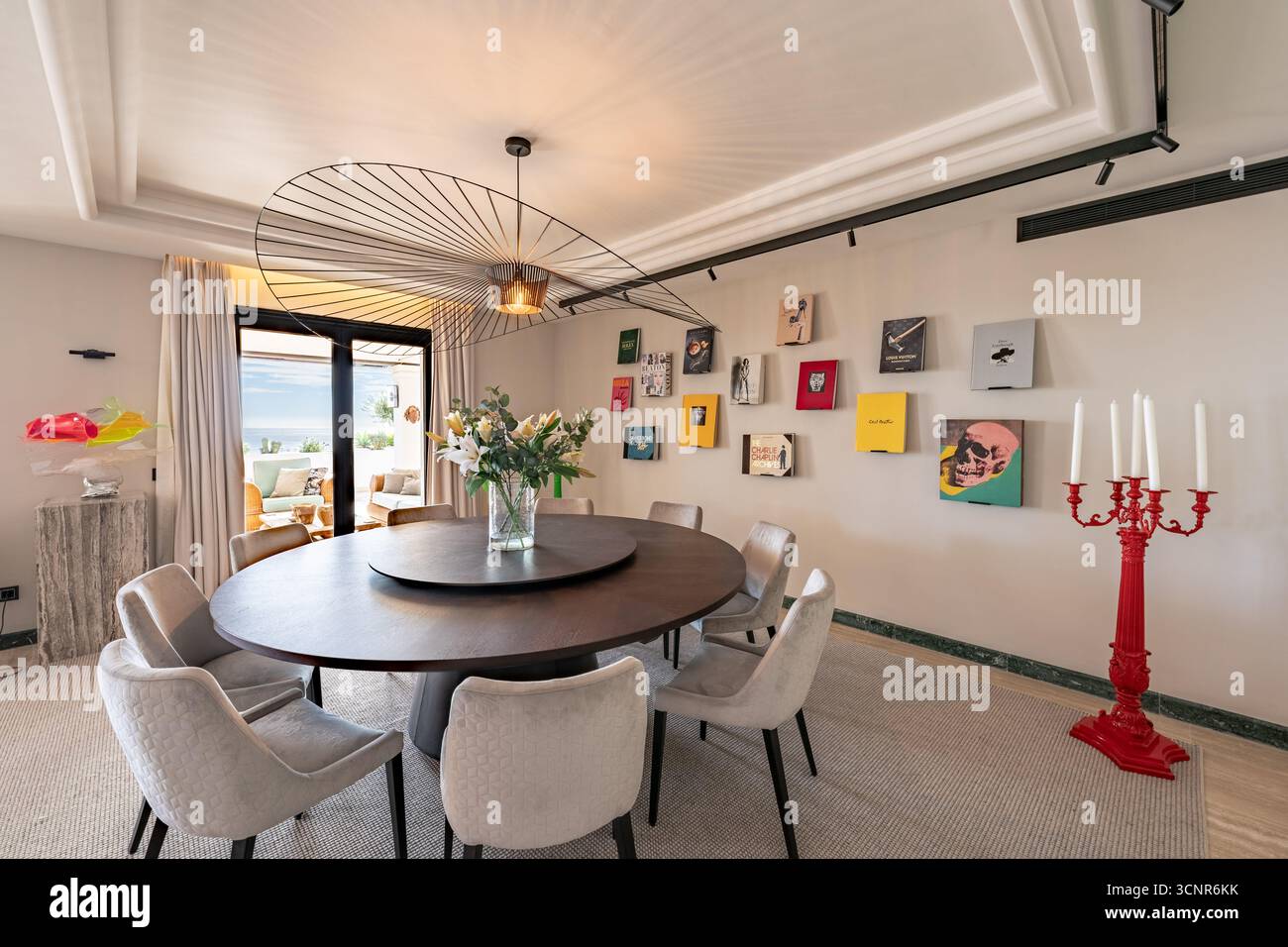 Sala da pranzo moderna ed elegante con tavolo rotondo e arredi unici nell'attico mediterraneo Foto Stock