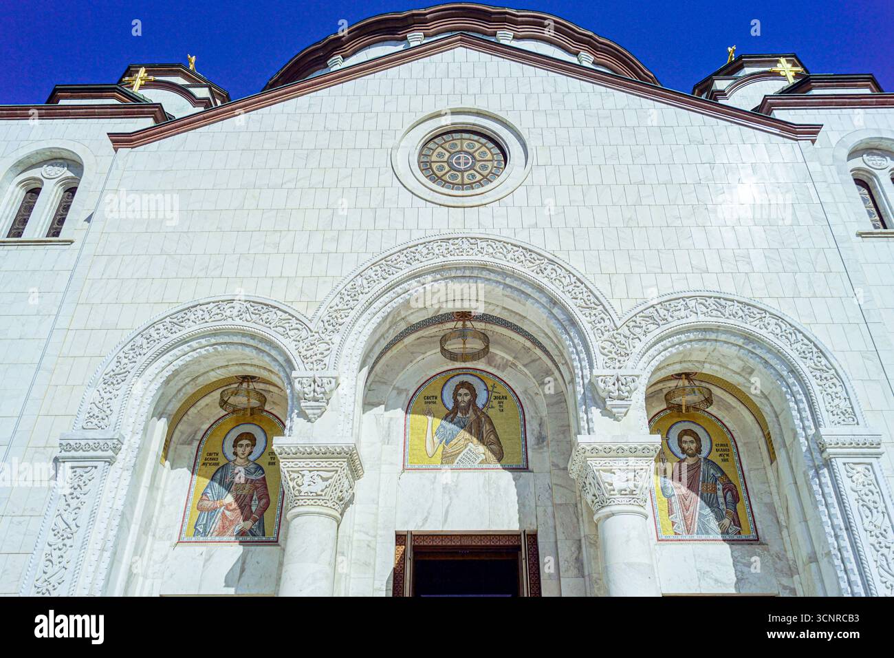 Facciata ornata della Chiesa di Santa Sava a Belgrado: Ingresso con mosaici dorati e intricate opere in pietra. Un capolavoro dell'arte religiosa serba Foto Stock