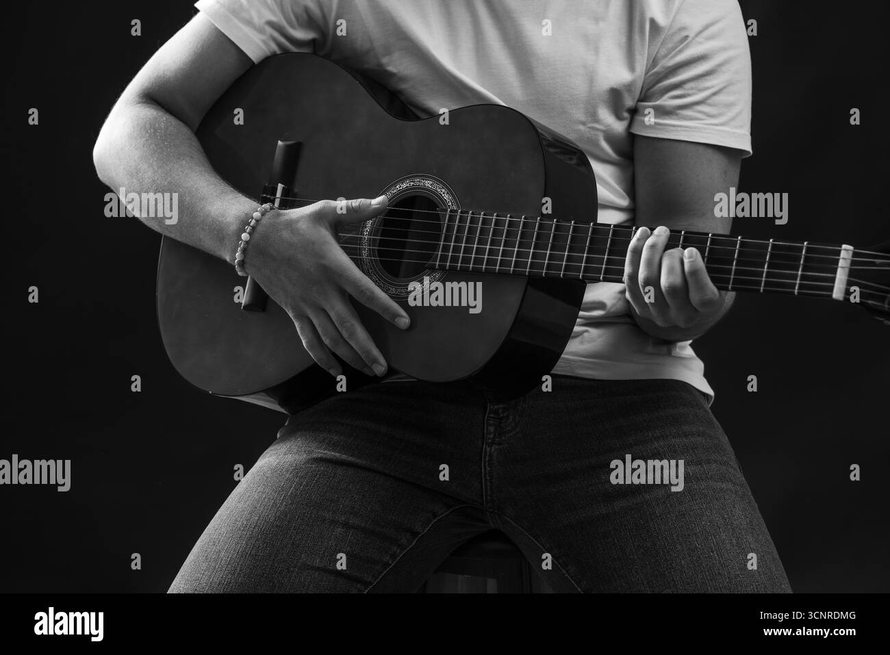 Primo piano in bianco e nero di un uomo che suona la chitarra acustica. Foto di alta qualità Foto Stock