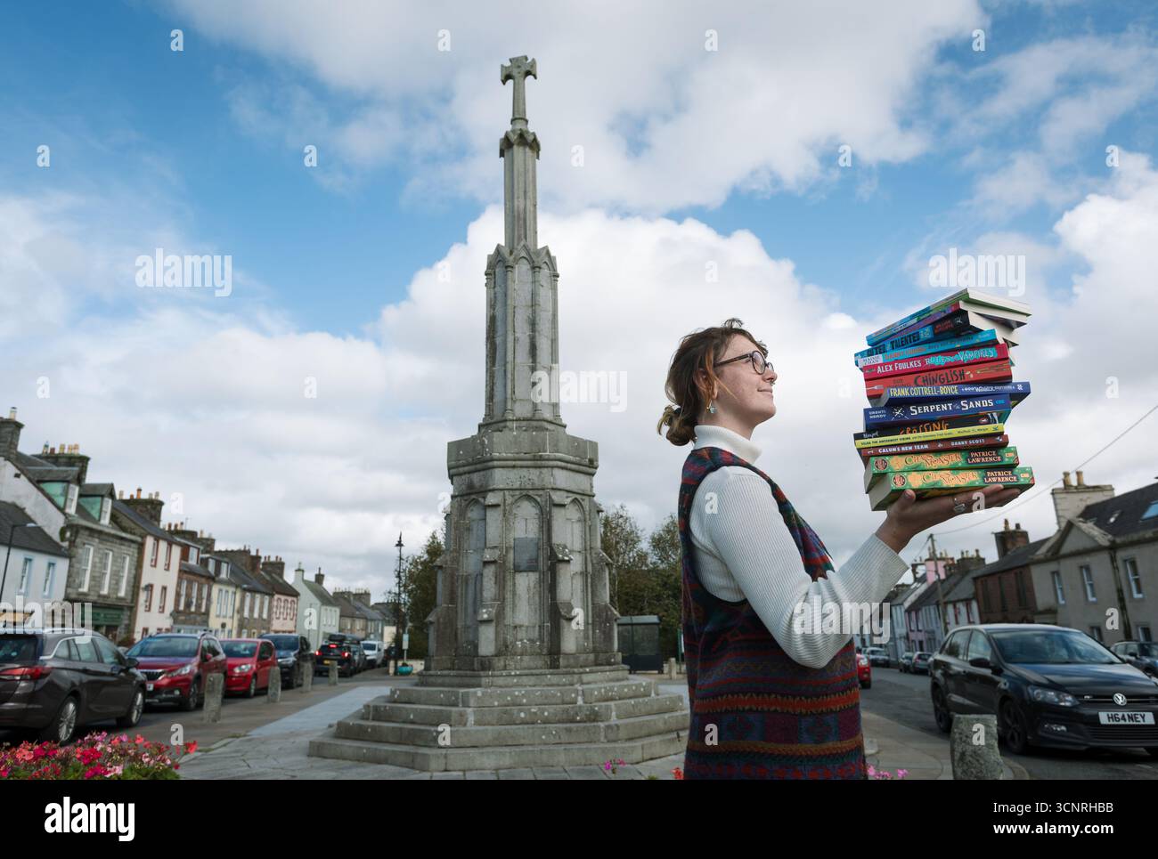 Donna che tiene un mucchio di libri a Wigtown, in Scozia, che tiene un festival annuale del libro. Foto Stock