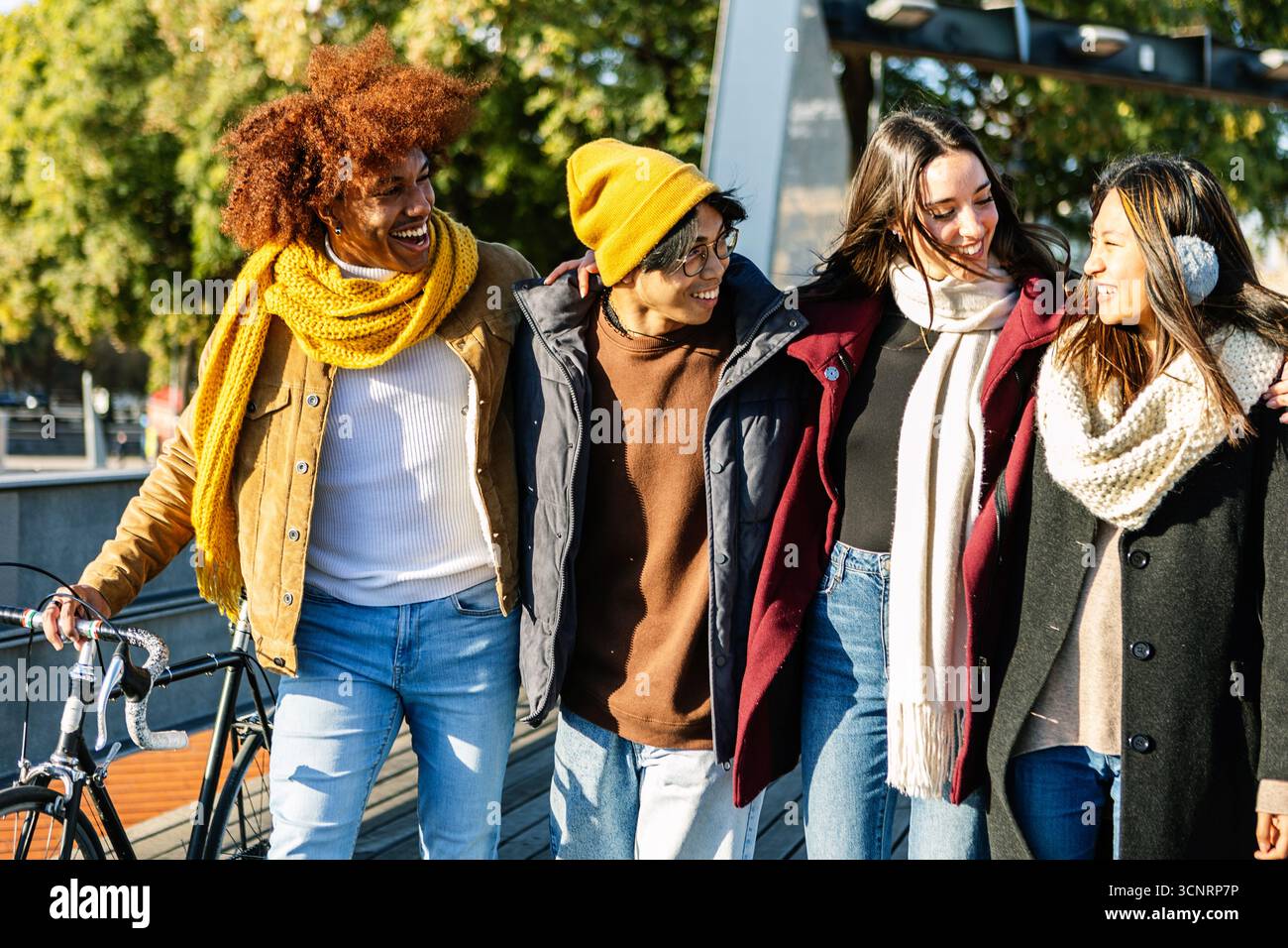Felici amici multietnici che camminano insieme nelle soleggiate giornate invernali Foto Stock