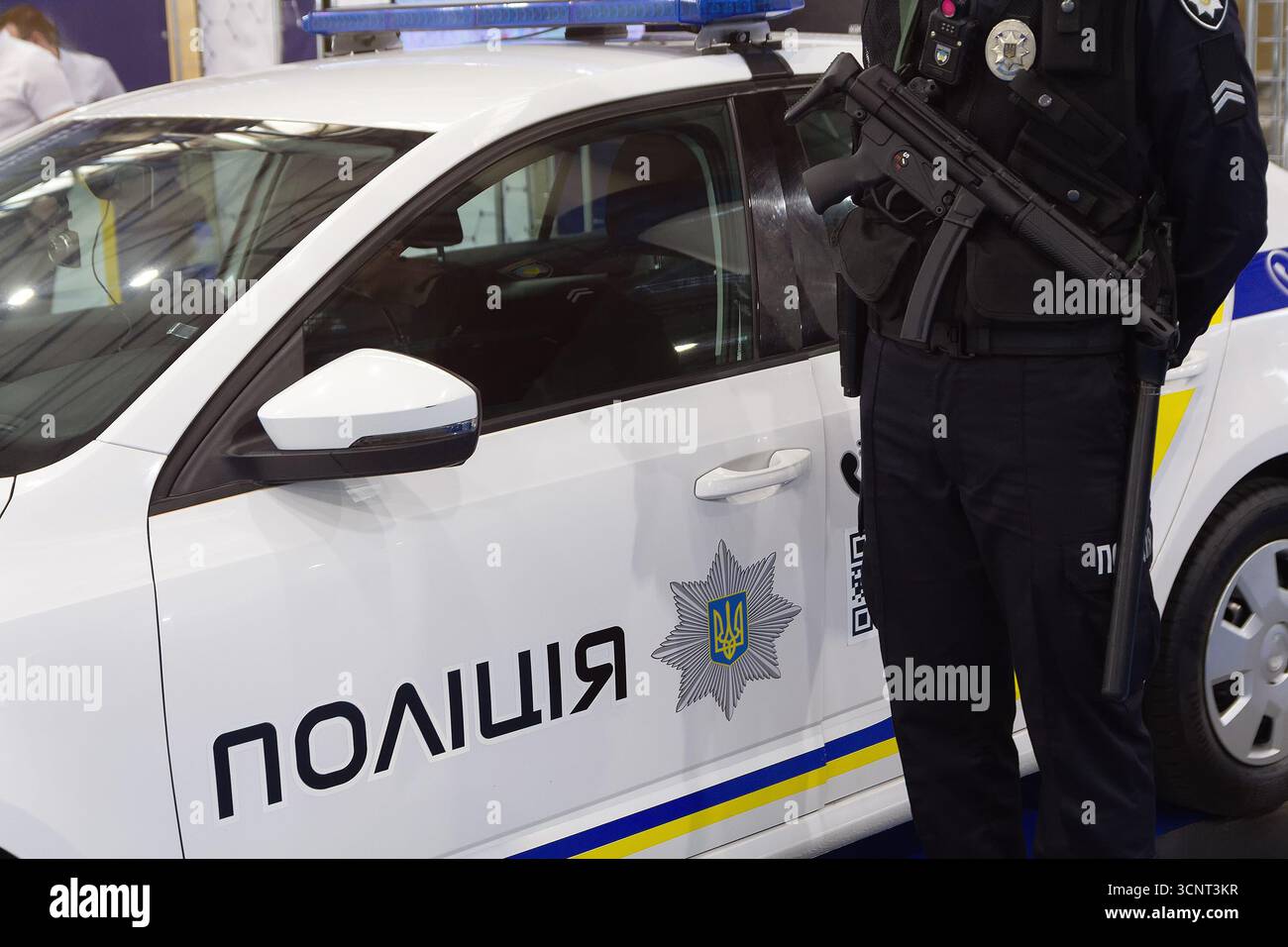 Ufficiale di polizia ucraino con armi vicino a un'auto di servizio. Sicurezza Foto Stock