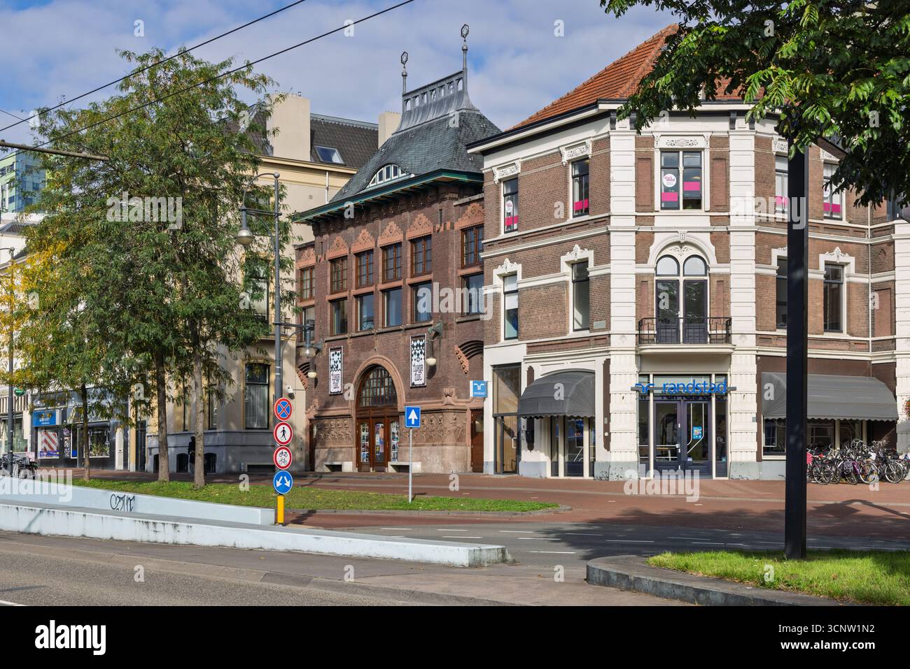 Una vista sulla strada ad Arnhem, Paesi Bassi, che mostra il caratteristico edificio storico in mattoni del Luxor Live Music e gli edifici adiacenti sotto una chiara S Foto Stock