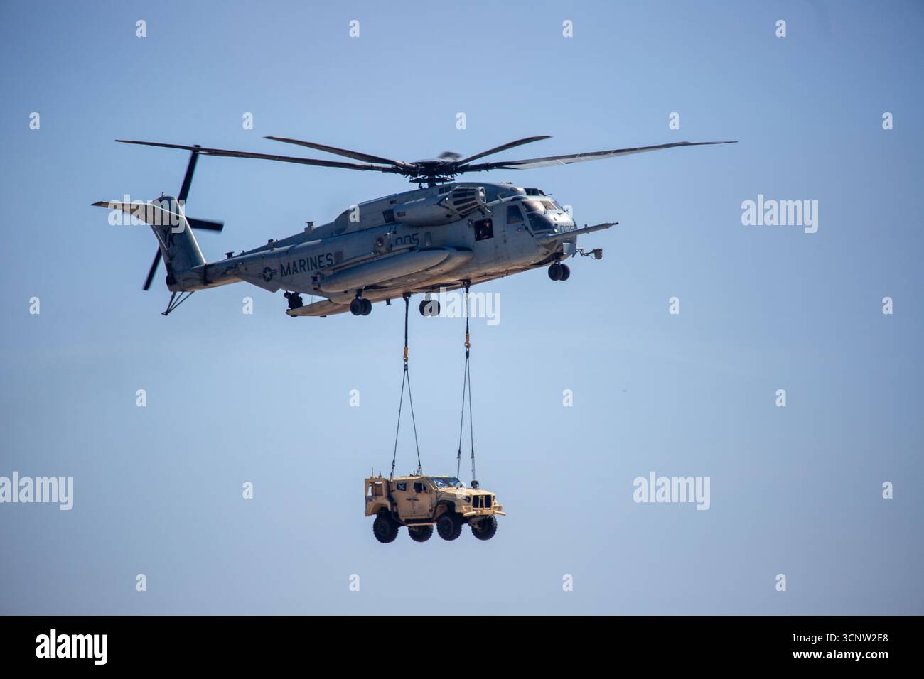 San Diego, California USA – 29 settembre 2024: Un Sikorsky CH-53E Super Stallion del corpo dei Marines degli Stati Uniti trasporta un Humvee HMMWV su un carico di imbracatura esterno durina Foto Stock