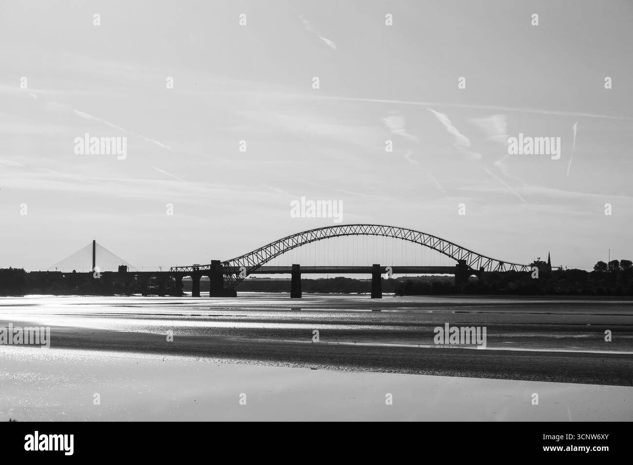 Vista in bianco e nero del Runcorn Widnes Bridge, noto anche come Silver Jubilee Bridge, che si staglia contro il cielo Foto Stock