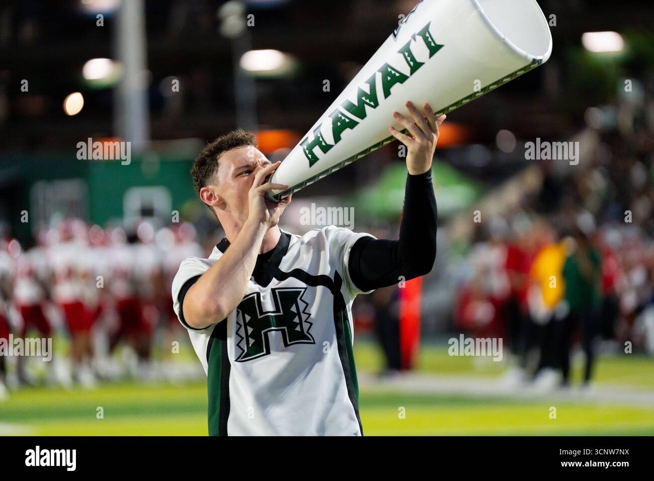 Con una passione e una forza inarrestabili, le basi cheerleader dell'Università delle Hawaii guidano la carica, alimentando l'energia della folla in una calda battaglia di calcio Foto Stock