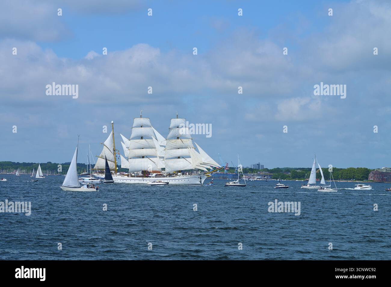 Una grande nave a vela Gorch Fock circondata da piccole barche sull'acqua, Windjammer Parade Kiel 2025, Heikendorf, Ploen District, Kiel Fjord, Schlesw Foto Stock