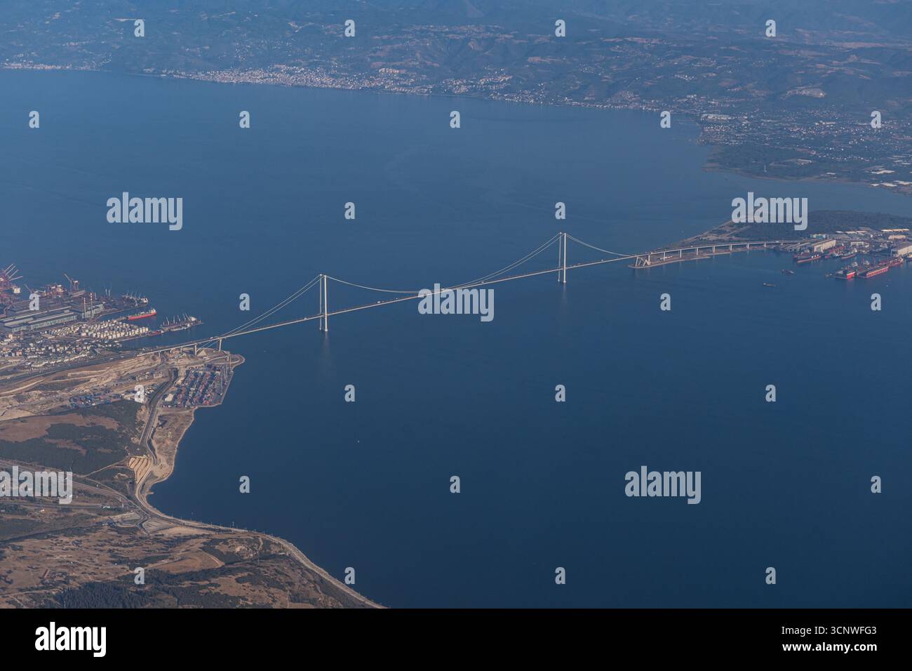 Una splendida vista aerea da un aeroplano cattura l'ampia costa greca e un maestoso ponte che si estende attraverso le acque blu profonde, che circondano Foto Stock