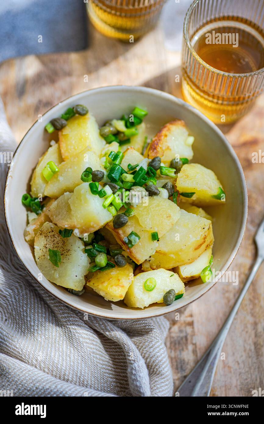 Una vivace insalata greca di patate con teneri patate, capperi ed erbe fresche. Questo piatto rinfrescante è perfetto come pasto leggero o come contorno, traboccante Foto Stock