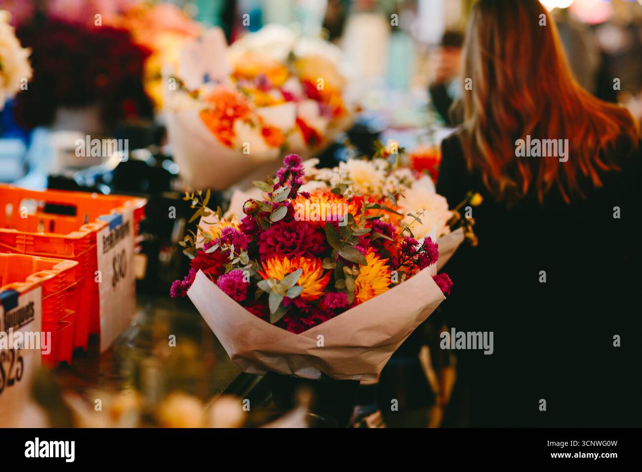 Un vivace mercato dei fiori a Seattle espone vivaci mazzi autunnali in un ambiente vivace. Gli acquirenti curiosano tra le fioriture colorate, catturando essen Foto Stock