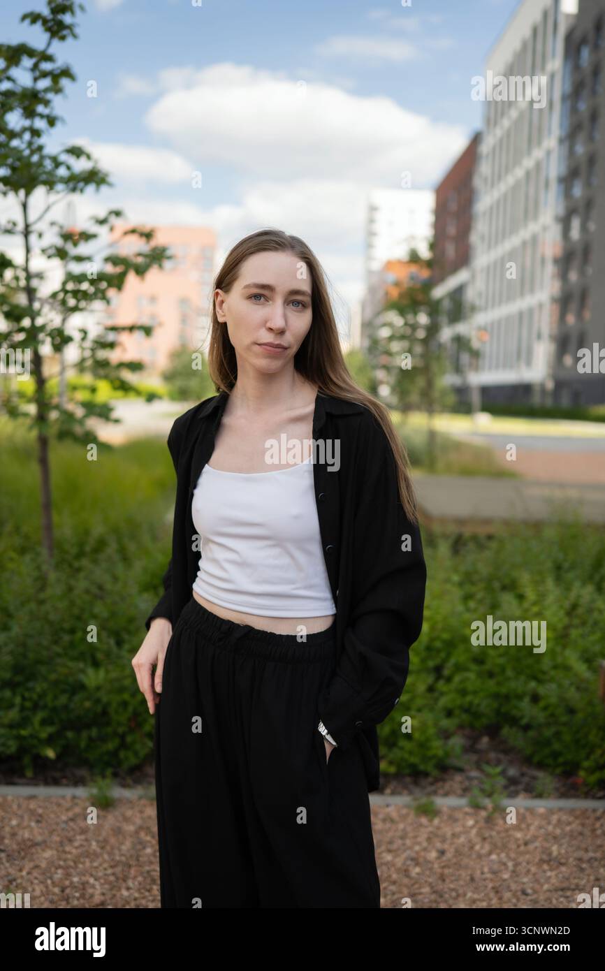 Giovane biologa donna che esplora l'intersezione tra ambienti urbani e ecosistemi naturali, mostrando il rapporto tra la vita urbana moderna Foto Stock