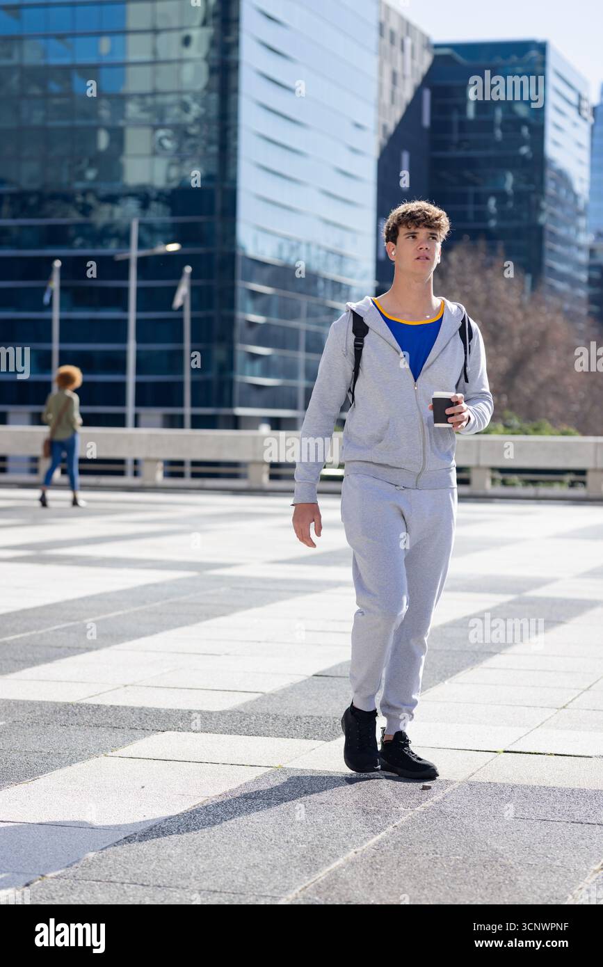 Diversi pedoni attraversano la piazza attraverso torri di vetro, zaino e tazza di caffè, spazio per fotocopie Foto Stock