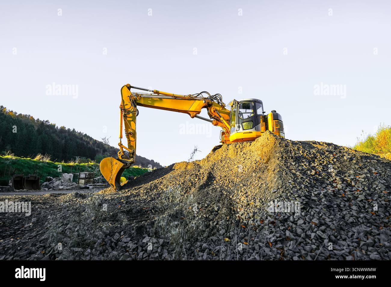 Un escavatore giallo in un cantiere. Foto Stock