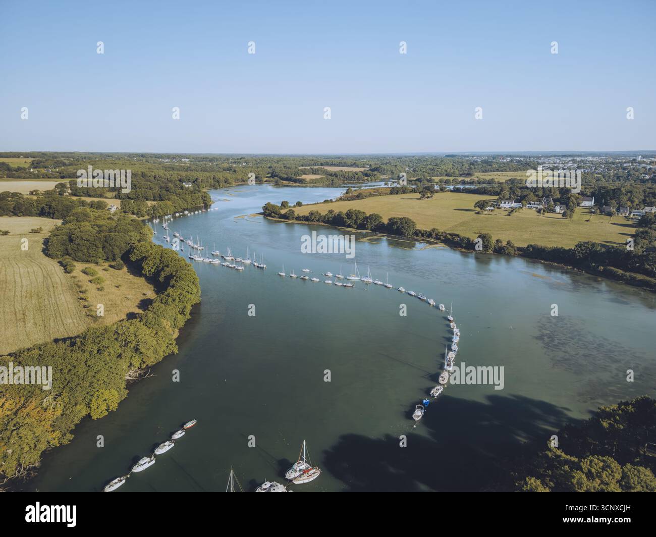 Vista aerea delle barche che costeggiano il tranquillo corso d'acqua vicino al lussureggiante paesaggio verde di Presqu'île de Conleau, Bretagne, Francia. Foto Stock
