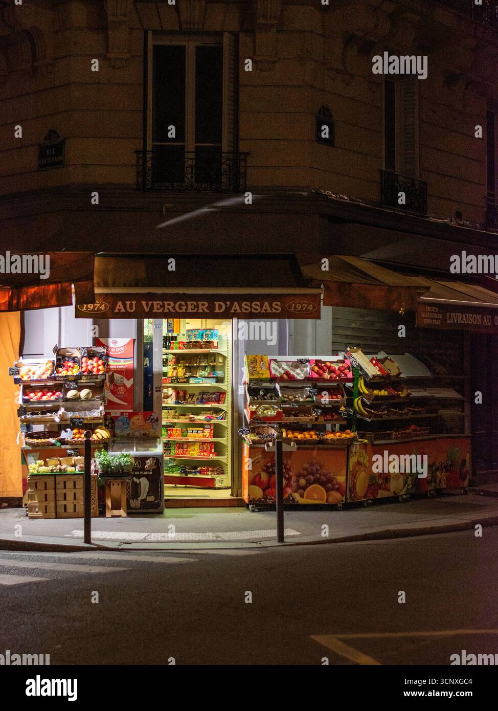 Di fronte a un negozio di alimentari di notte a Parigi Foto Stock