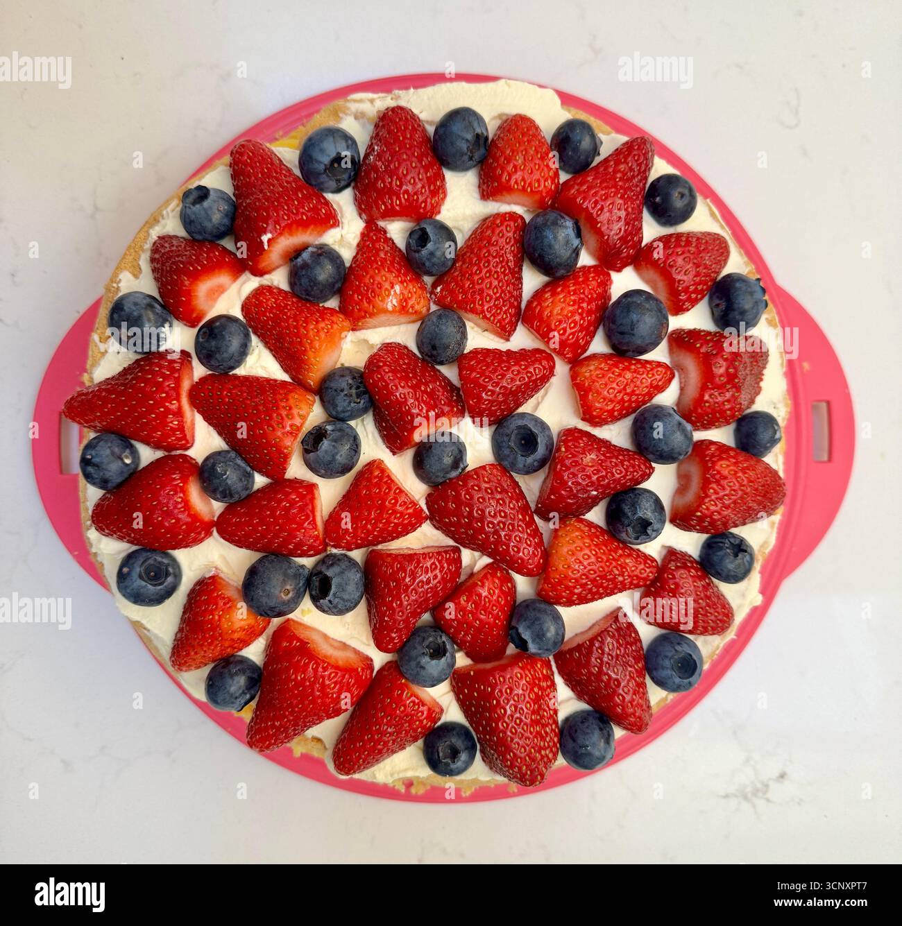 Vista dall'alto della torta in spugna fatta in casa decorata con fragole e mirtilli panna - Immagine stock catturata con smartphone