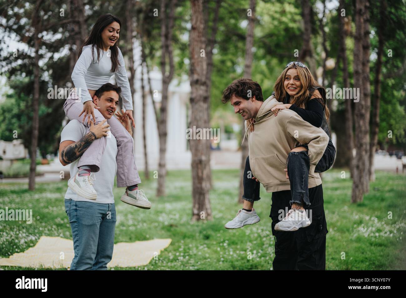 Amici che giocano e fanno giostre in un parco in una giornata di divertimento all'aperto Foto Stock