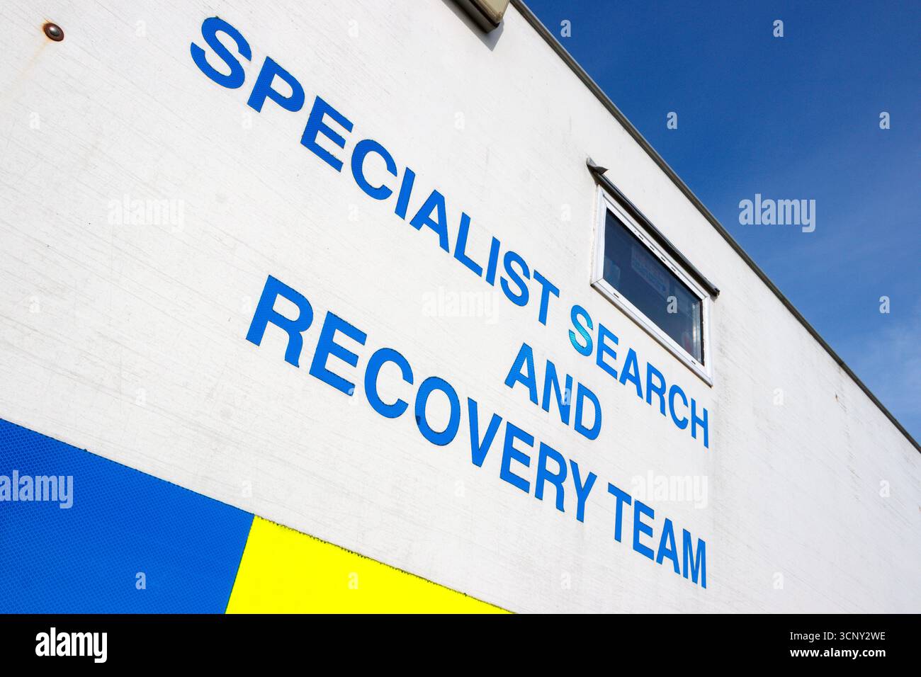 Scritta sul lato del camion della polizia che mostra un testo blu di grandi dimensioni che legge il team di ricerca e recupero specializzato con una finestra sopra in una giornata di sole Foto Stock Scritta sul lato del camion della polizia che mostra un testo blu di grandi dimensioni che legge il team di ricerca e recupero specializzato con una finestra sopra in una giornata di sole Foto Stock