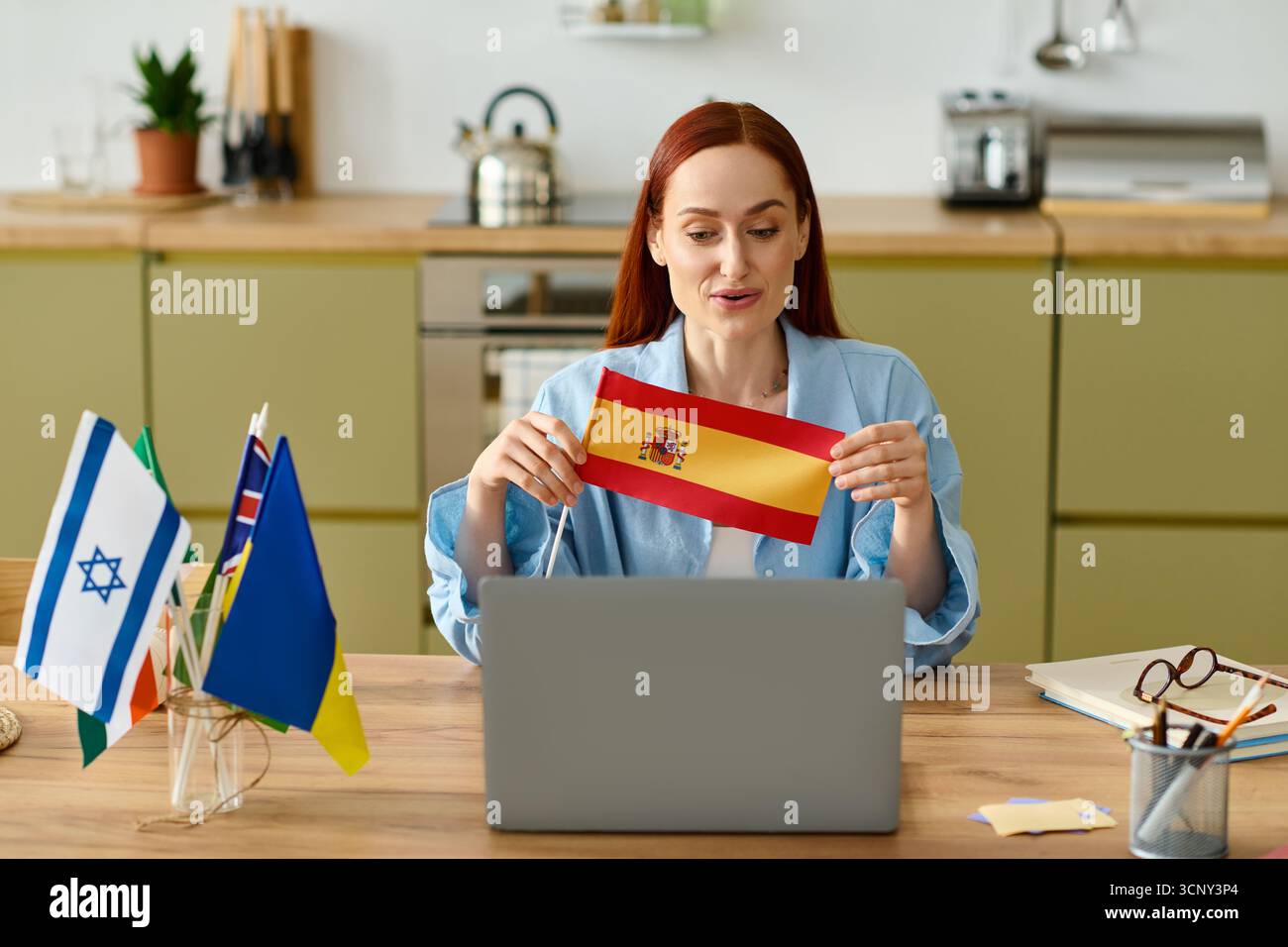 Insegnante dai capelli rossi condivide il suo entusiasmo per le lingue mentre insegna online da casa. Foto Stock