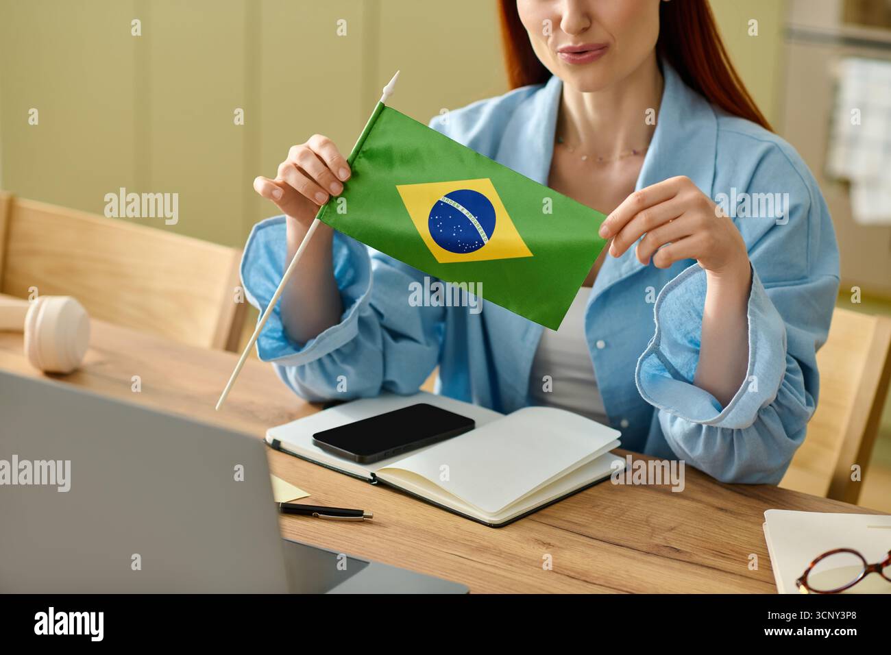 Insegnante dai capelli rossi conduce una lezione online sulla lingua e la cultura brasiliane a casa. Foto Stock