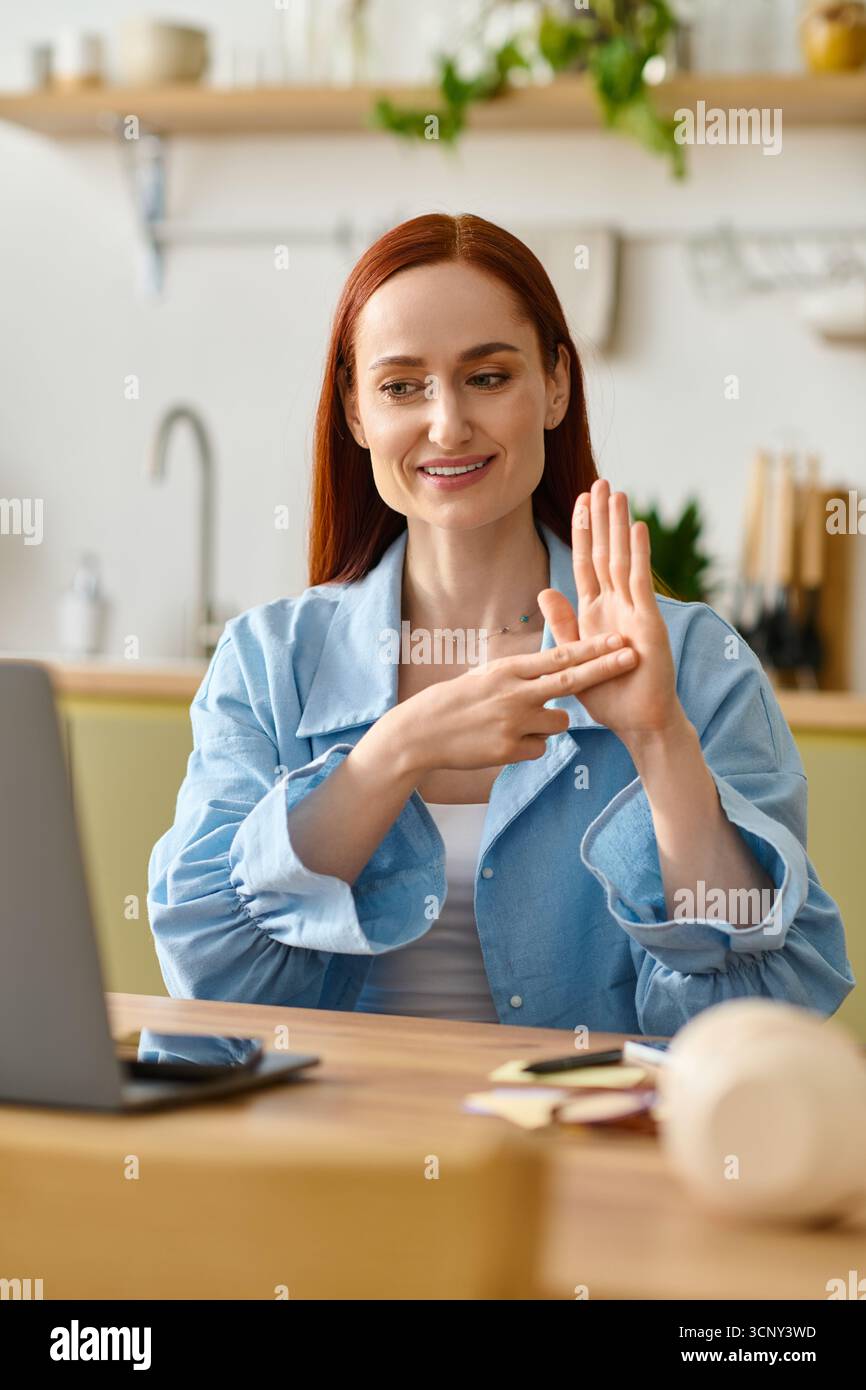 L'insegnante di lingua con i capelli rossi interagisce con gli studenti online dal suo invitante ambiente domestico. Foto Stock