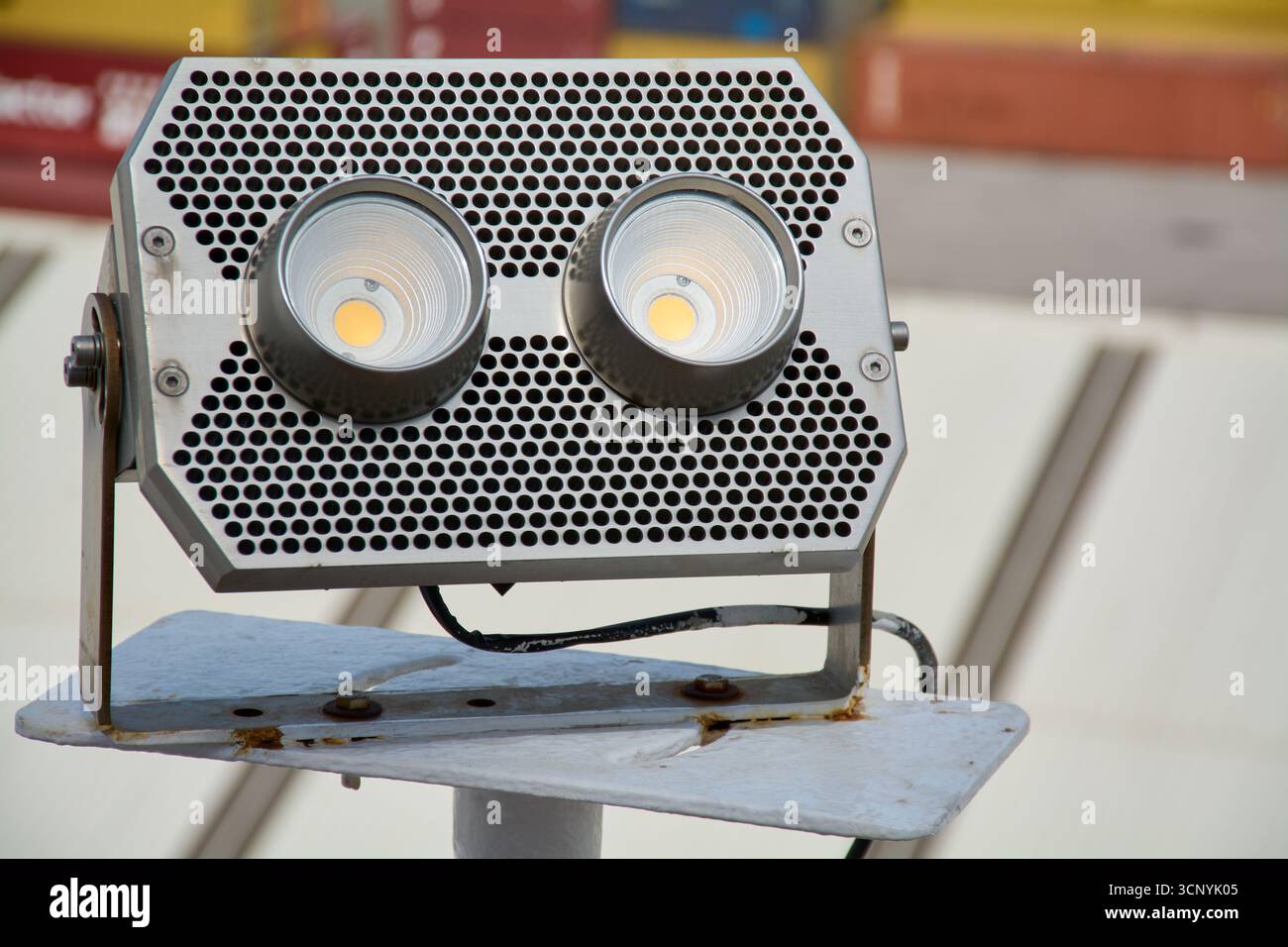 Primo piano di un proiettore industriale con tecnologia LED, progettato per un'illuminazione potente ed efficiente in ambienti di lavoro all'aperto. Foto Stock