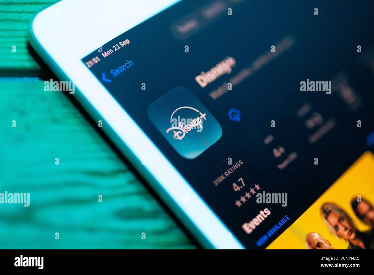 IPad su un tavolo in legno che mostra l'app Disney+ sull'App Store, la tecnologia moderna e il concetto di stile di vita digitale Foto Stock