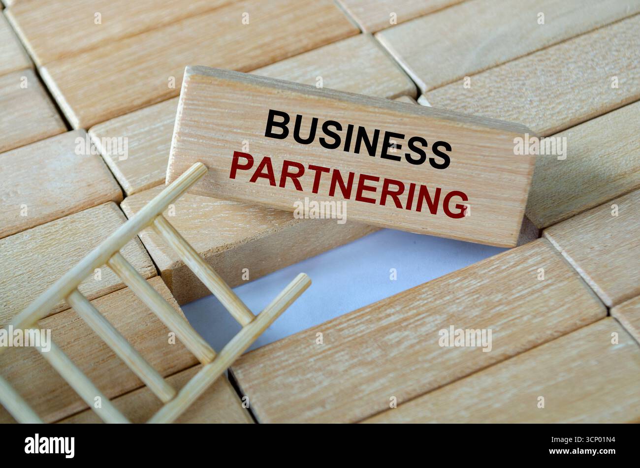 Testo di partnership aziendale scritto su blocchi di legno disposti su una scala che illustra la collaborazione per il successo reciproco Foto Stock