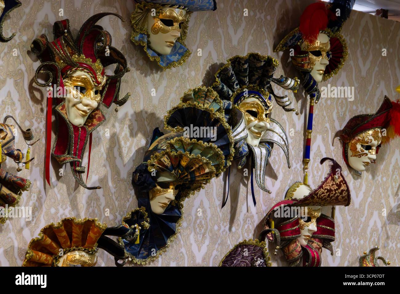 Le maschere veneziane adornano l'elegante esposizione a parete Foto Stock