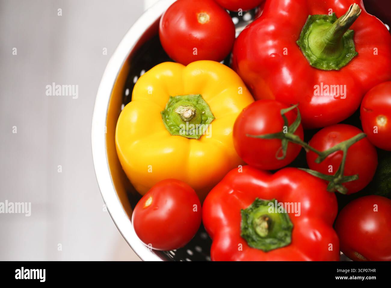 Peperoni rossi e gialli freschi in un recipiente bianco. Verdure biologiche da cucinare. Primo piano su cibo sano. Concetto di nutrizione naturale. Foto Stock