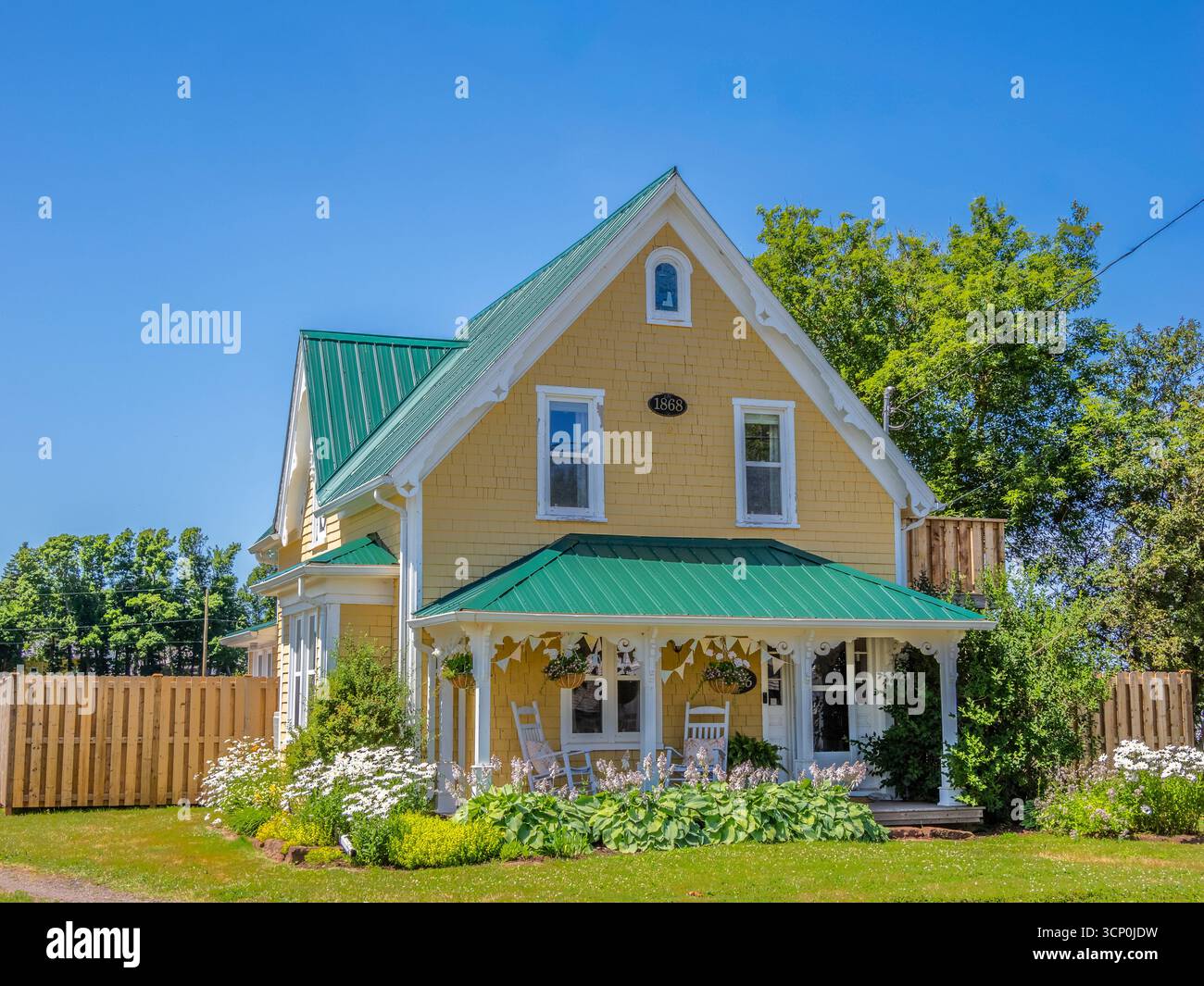 Casa gialla con tetto verde e veranda a New London sull'Isola del Principe Edoardo in Canada Foto Stock