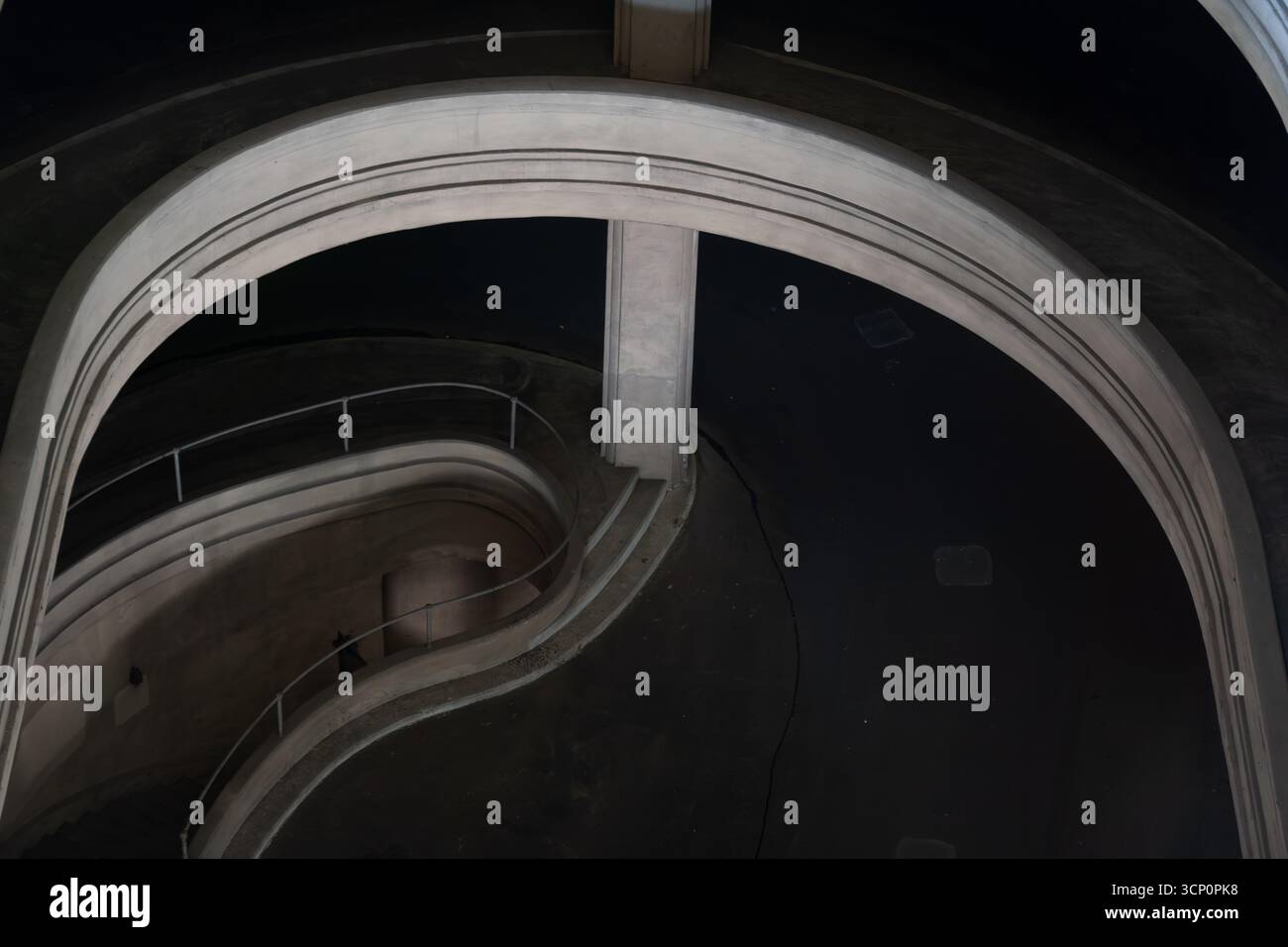 La scala a chiocciola curva all'interno della torre circolare, suggestivi interni architettonici con ombre e luce, che mostrano ringhiere curve e grandi monumenti come lo spazio Foto Stock