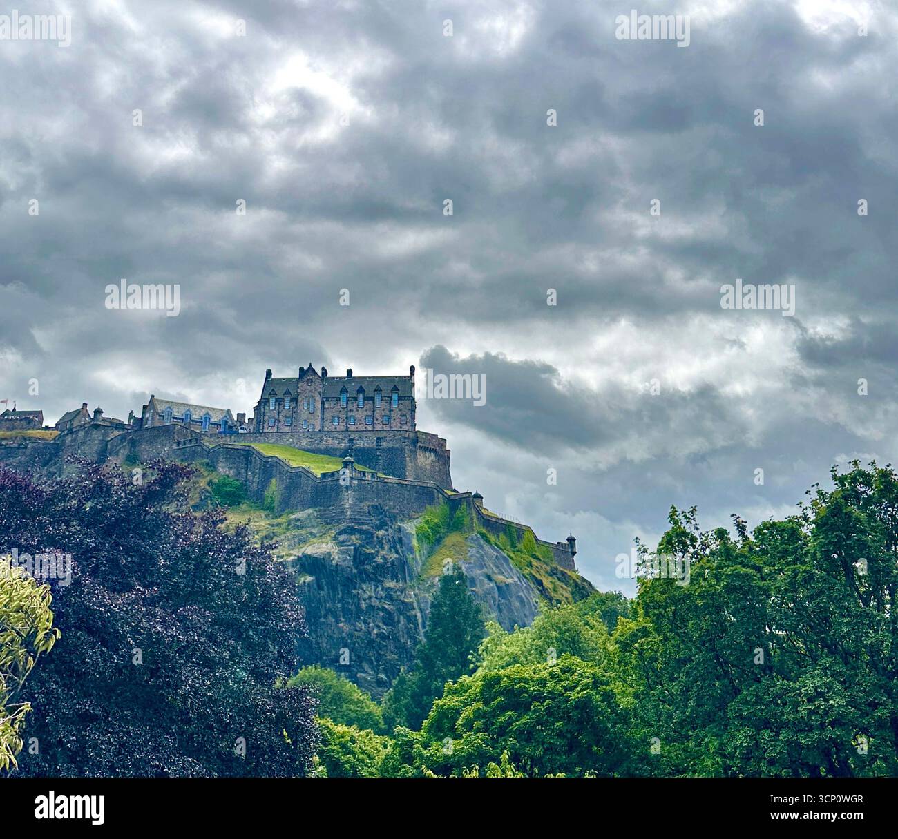 Il castello di Edimburgo visto da Princes Street sotto, contro un cielo tempestoso Foto Stock