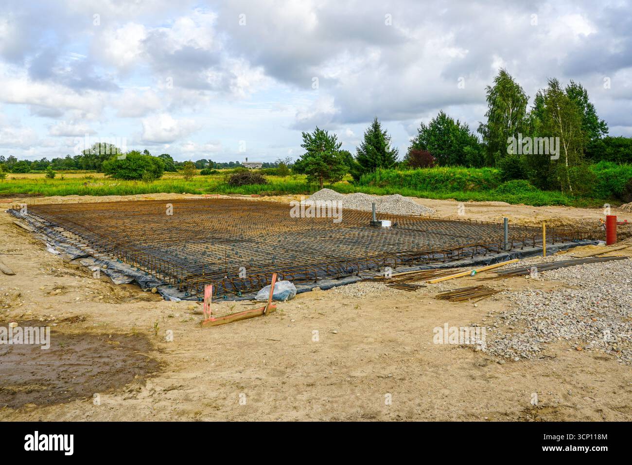 Fondamenta grandi preparate con rete di armature in acciaio e barriera al vapore in plastica, pronte per il versamento di solette in calcestruzzo in cantiere Foto Stock