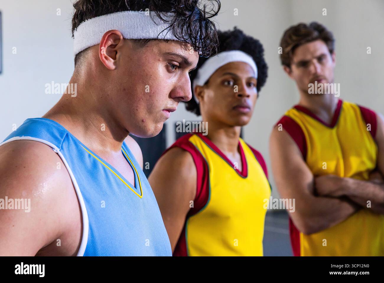 Giocatori di basket adolescenti in piedi sul campo che guardano il tabellone segnapunti con fasce Foto Stock